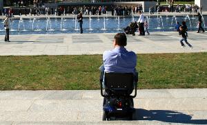 Hombre en silla de ruedas, solo, mirando y observando a otros