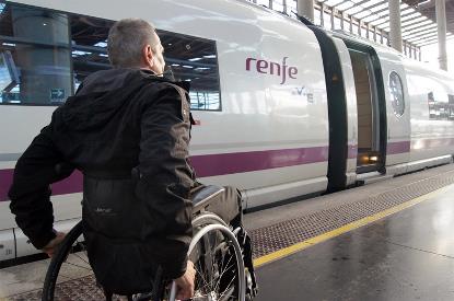 Una personas en silla de ruedas se dirige a un tren de Renfe