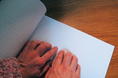 Detalle de las manos de una mujer leyendo en braille 