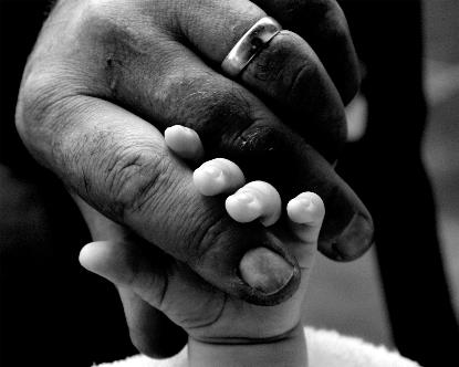 Detalle de la mano de una padre sosteniendo la de su hijo