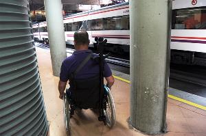 Un usuario de silla de ruedas pasa por un andén de Cercanías, en Atocha, con varios obstáculos