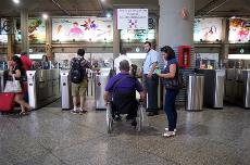 Una personas en silla de ruedas accede a una estación de tren