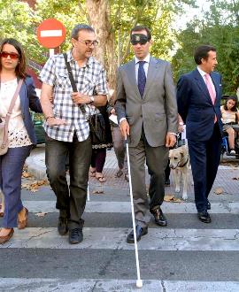 El consejero de Asuntos Sociales de la Comunidad de Madrid, Salvador Victoria, con los ojos taapdos cruzando un paso de peatones 