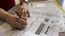 Una persona rellena el formulario de la declaración de la renta (imagen de la web de Plena Inclusión)