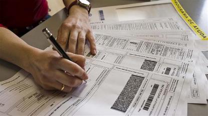 Una persona rellena el formulario de la declaración de la renta (imagen de la web de Plena Inclusión)