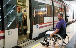 Un hombre en silla de ruedas en una estación de tren de cercanías