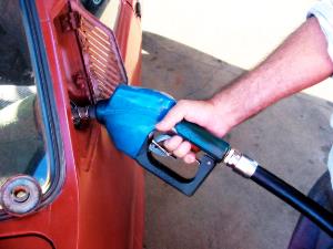 Una mano echando combustible al coche