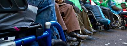 Detalle de las piernas y la parte baja de las sillas de ruedas de varios usuarios con discapacidad