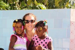 Mónica Estacio con dos pequeñas haitianas