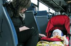 Mujer con un bebé en su silla en un autobús