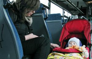 Mujer con un bebé en su silla en un autobús