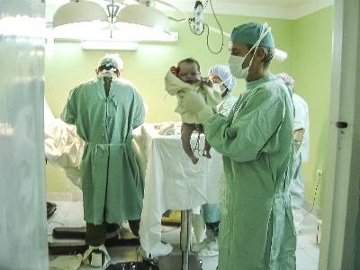 Un médico con un bebé recién nacido entre sus manos