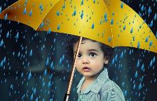 Un niño se protege bajo un paraguas