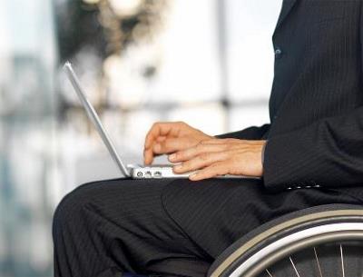 Detalle de un usuario de silla de ruedas con su portátil