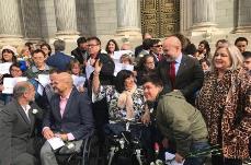 Imagen a las puertas del Congreso de los Diputados de personas del sector de la discapacidad celebrando la reforma de la Loreg