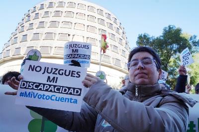 Una persona muestra un cartel que dice: no juzgues mi discapacidad, mi voto cuenta