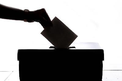 Imagen de una mujer depositando su voto en una urna.