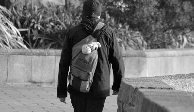 Joven de espaldas camina con mochila