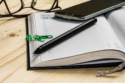 Agenda, gafas, móvil y bolígrafo sobre una mesa