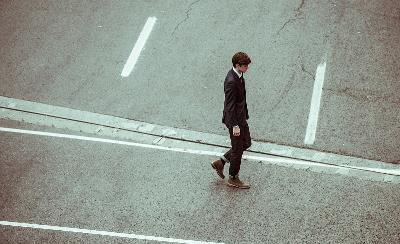 Un hombre trajeado paseo solo por una calle