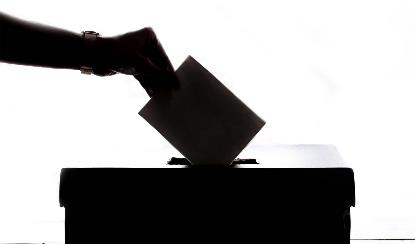 Dibujo de una persona depositando su voto en una urna.