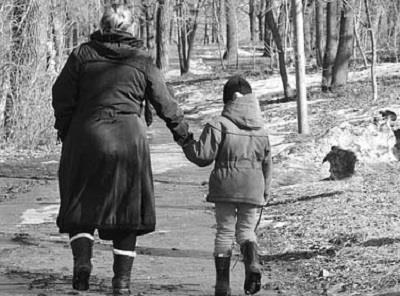 Una mujer pasea de la mano con un menor