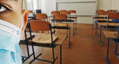 imagen de un alumno con mascarilla en un aula vacía