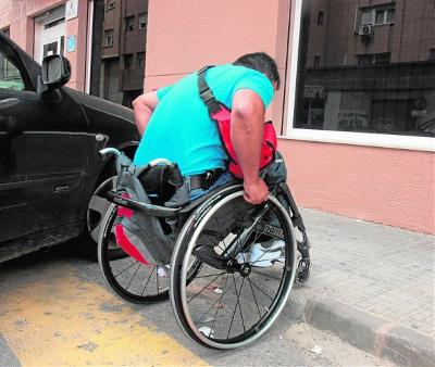 Imagen de CERMI Aragón sobre un hombre en silla de ruedas que intenta salvar un escalón de una acera