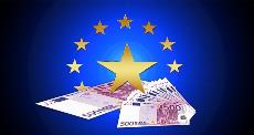 Imagen de billetes de euro sobre símbolo de la Unión Europea