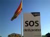 La bandera de España en Colón y un cartel de SOS Discapacidad