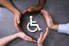 Símbolo de discapacidad rodeado por manos de distintos colores
