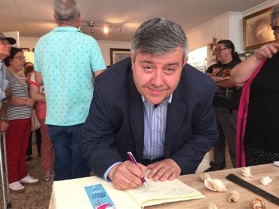 Miguel Paraíso firmando un documento.