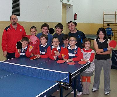 Basilio García y algunos de los niños a los que enseña tenis de mesa