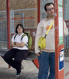 Dos jóvenes con síndrome de Down, ante una parada de autobús accesible