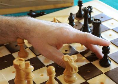 Una mano mueve una pieza de ajedrez.