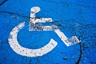 Símbolo de la discapacidad, silla de ruedas, pintado en el suelo, pisoteado y viejo