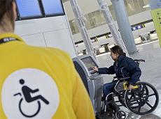 Detalle de un empleado de AENA atendiendo a un pasajero con movilidad reducida