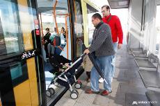 Usurio del tranvía de Tenerife entrando a un vagón con un carrito de bebés