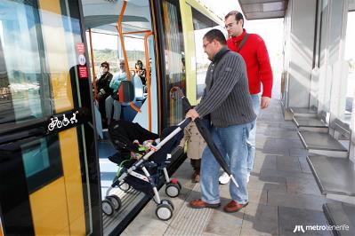 Usurio del tranvía de Tenerife entrando a un vagón con un carrito de bebés