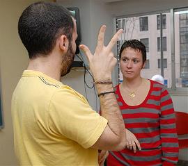 Un voluntario enseña lengua de signos a una persona con ceguera