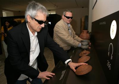 Visitantes ciegos en el Museo Arqueológico Nacional tocando piezas del museo