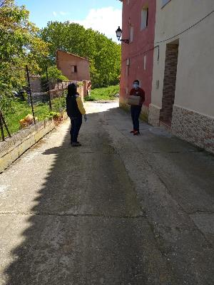 Un cartero entrega material a una persona en un pueblo.