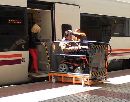 Acceso al tren de una persona en silla de ruedas mediante una plataforma elevadora y la ayuda del servicio de asistencia al viajero