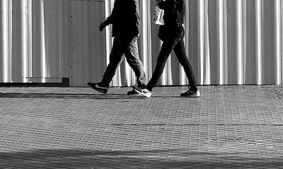 imagen recortada con las piernas de dos personas paseando