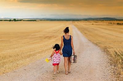 Una mujer con una niña de la mano