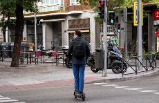 Hombre en patinete circulando sobre paso de peatones